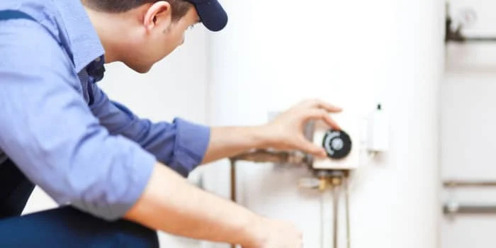 plumber inspecting water heater tank in Columbus, Columbus Water Heater Pros provides water heaters installations, repair and replacement.